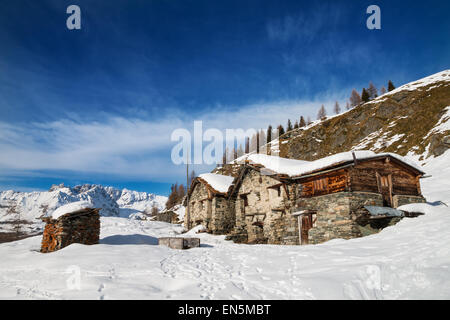 abandoned  typical chalet in  italian alps under blue sky with some white clouds Stock Photo