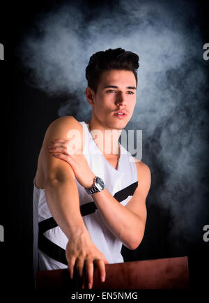 Portrait of handsome young man leaning on wood plank, Stock Photo