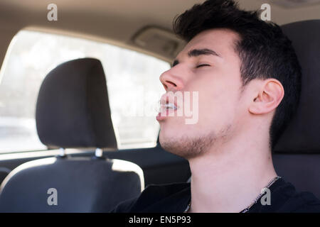 Young man sleeping at the wheel driving his car Stock Photo