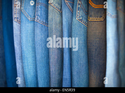 Diverse shades of blue denim trousers, arrayed in an overlapping pattern for shoppers to examine. Stock Photo