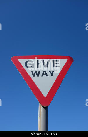 Give Way road sign against a blue background UK Stock Photo