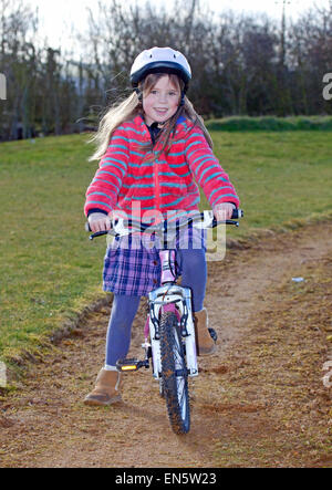 6 year old riding her bike with helmet Stock Photo