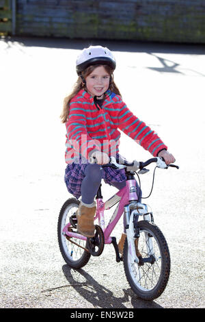 6 year old riding her bike with helmet Stock Photo