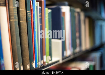 Multi coloured books in university library stacks shot obliquely titles not visible Stock Photo