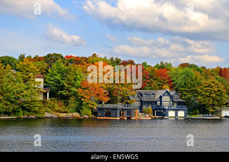 Million dollar cottages along Lake Moskoka near Gravenhurst, Ontario, in autumn. Photographed on a boat in Lake Muskoka. Stock Photo