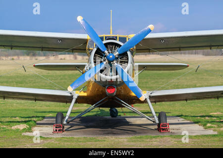 Biplane with blue blue propeller. Old plane close-up. Front view, with the side of the fuselage. Clear sunny day. Stock Photo