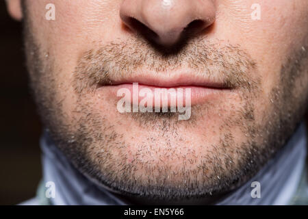 Tight portrait of a confident man with high contrast lighting wearing sunglasses. With beard stubble. Stock Photo