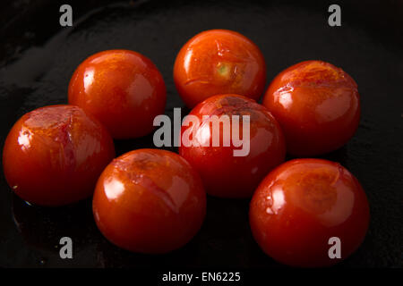 Series: Grilling Strip Loin Steak in Cast Iron Frying Pan: Ingredient grilled tomatoes prepared first Stock Photo