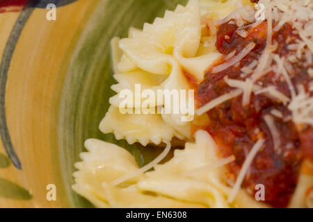 Italian pasta dinner served with Marinara sauce, parmesan cheese, over bow tie noodles accompanied by a glass of Chianti wine an Stock Photo