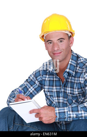 Worker writing in notebook Stock Photo