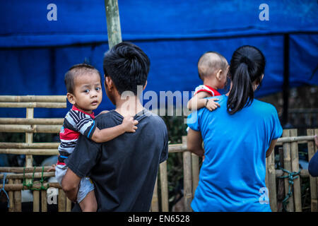 Tangerang, Indonesia. 28th Sep, 2014. A family look around where goats are tied together for sale after Eid al-Adha prayers at Asmaul Husna Masjid. Eid al-Adha, also known as the Feast of Sacrifice, commemorates prophet Abraham's willingness to sacrifice his son as an act of obedience to God, who in accordance with tradition then provided a lamb in the boy's place. © Garry Andrew Lotulung/Pacific Press/Alamy Live News Stock Photo