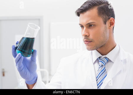 Concentrated scientist looking at beaker Stock Photo