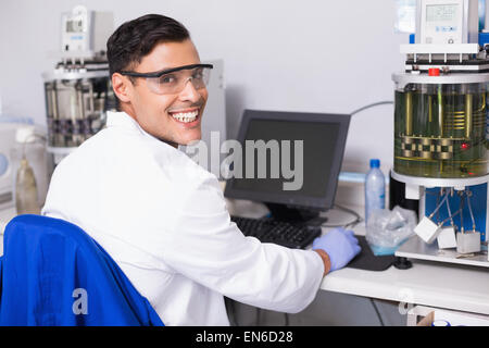 Smiling scientist working with computer Stock Photo