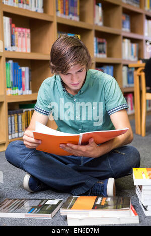 Student sitting on floor in library Stock Photo