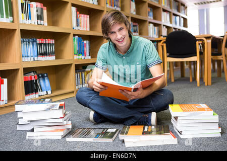 Student sitting on floor in library Stock Photo