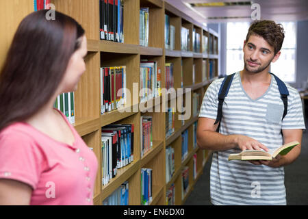 Students in the library smiling at each other Stock Photo