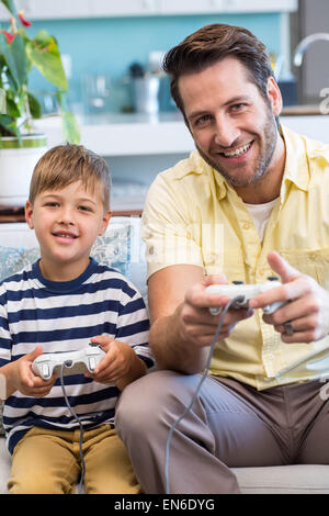 Father and son playing video games together Stock Photo