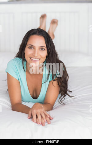 Happy brunette lying on bed Stock Photo - Alamy