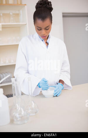 Concentrated scientist using pestle and mortar Stock Photo