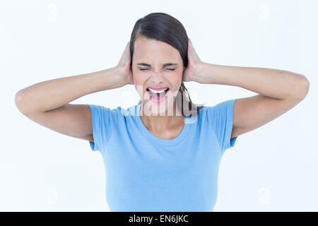 Screaming woman covering her ears Stock Photo