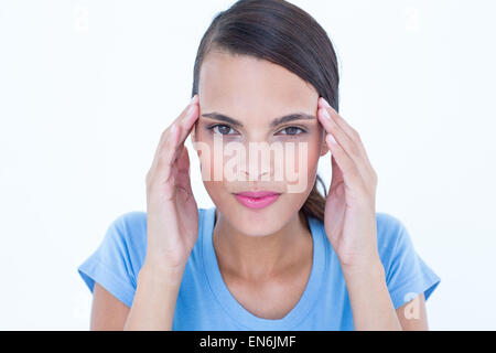 Pretty woman with headache touching her temples looking at camera Stock Photo