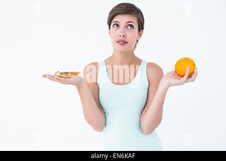 Woman choosing between pizza and an orange Stock Photo