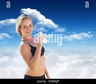 Composite image of fit blonde drinking water Stock Photo