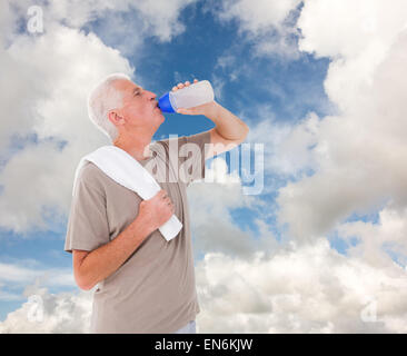 Composite image of fit man drinking water from bottle Stock Photo - Alamy