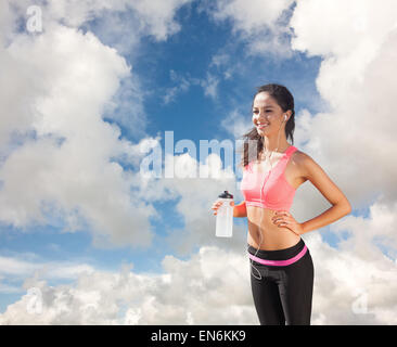 Composite image of beautiful smiling healthy woman holding water bottle Stock Photo