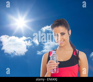 Composite image of fit woman holding water bottle Stock Photo