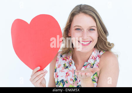 Woman holding heart card and blowing kiss Stock Photo