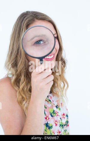 Smiling woman holding magnifying glass Stock Photo