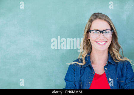 Smiling geeky teacher standing in front of blackboard Stock Photo