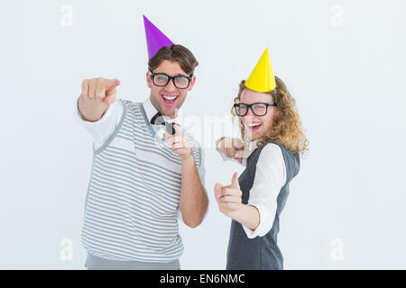 Happy geeky hispser couple dancing with party hat Stock Photo
