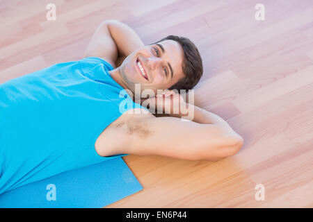 Smiling man lying on exercise mat Stock Photo