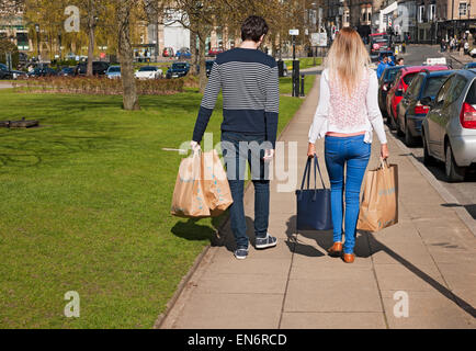 Young man and woman couple people carrying Primark shop store carrier shopping bags Harrogate North Yorkshire England UK United Kingdom Great Britain Stock Photo