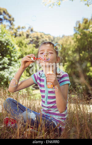 Cute little girl blowing bubbles Stock Photo