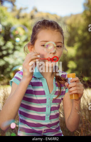 Cute little girl blowing bubbles Stock Photo