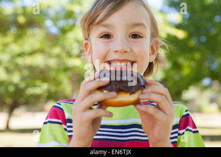 Little boy eating chocolate doughnut Stock Photo