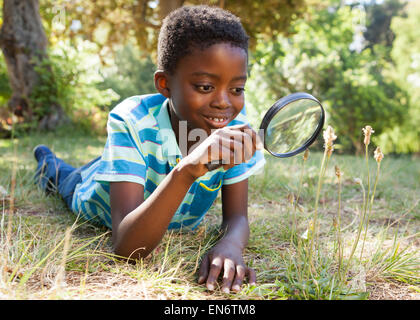 Cute little boy looking through magnifying glass Stock Photo