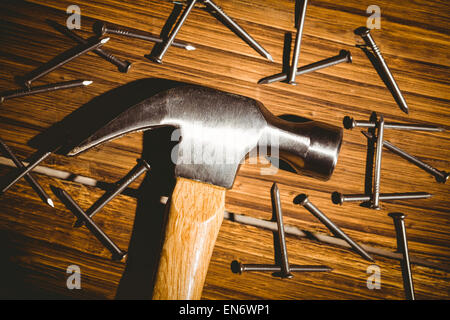 Hammer and nails laid out on table Stock Photo