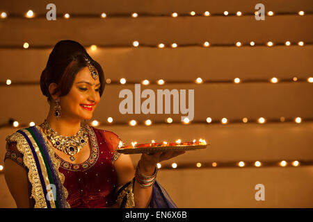 Woman holding a tray of diyas Stock Photo