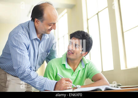 Student pouring liquid into beaker Stock Photo