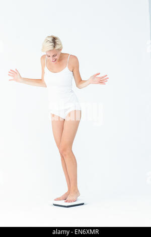 Happy woman standing on a scales Stock Photo