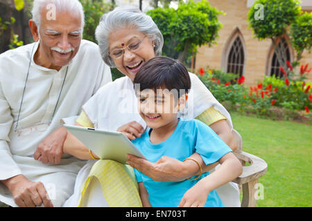 Grandparents showing digital tablet to grandson Stock Photo