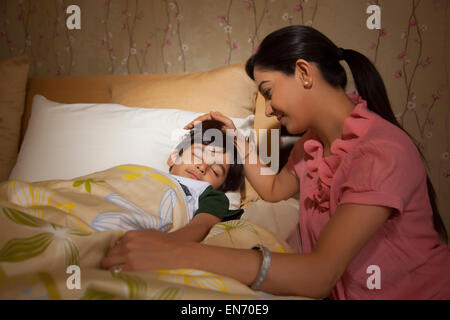 Mother putting to sleep son Stock Photo - Alamy