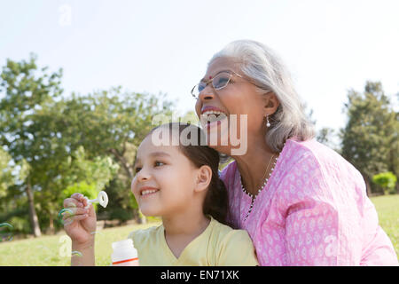 Grandmother and granddaughter blowing bubbles Stock Photo