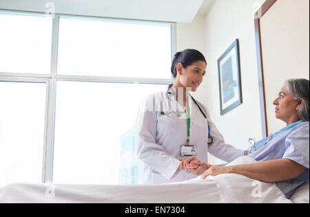 Female doctor holding patients hand Stock Photo