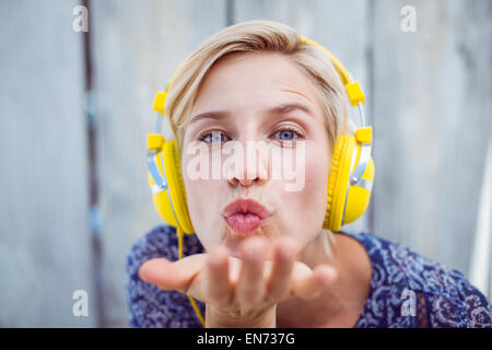 Pretty blonde woman listening music and blowing kiss Stock Photo