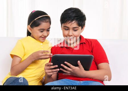 Brother and sister using digital tablet Stock Photo